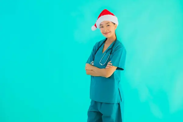 肖像美しい若いアジアの医師の女性は笑顔でクリスマスの帽子を身に着けています幸せな上の青隔離された背景 — ストック写真