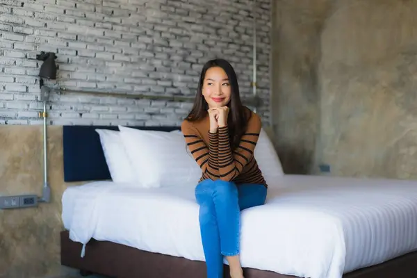 Young asian woman happy smile relax on bed in bedroom interior