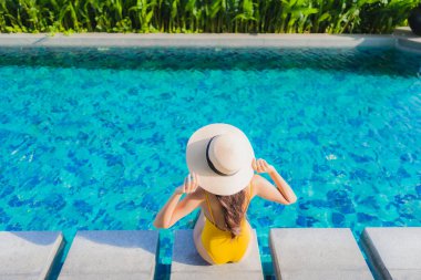 Güzel bir Asyalı kadın portresi. Rahatlayın. Keyifli bir tatil için oteldeki yüzme havuzunda mutlu bir gülümseme.