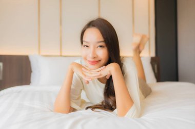 Güzel bir Asyalı kadının portresi. Gülümse. Yatak odasında rahatla.