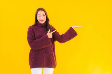 Güzel Asyalı kadın gülümsüyor. Sarı izole edilmiş arka planda başka bir eylemde mutlu.