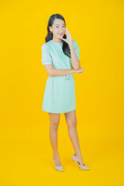 Portre güzel Asyalı kadın gülümsüyor. Renkli arka planda hareket var.