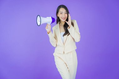 Güzel bir Asyalı kadının portresi. Arka planda megafonla gülümsüyor.