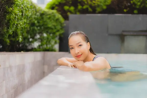 ポートレート美しい若いアジアの女性はレジャーや休暇のための屋外スイミングプールの周りの笑顔をリラックス — ストック写真