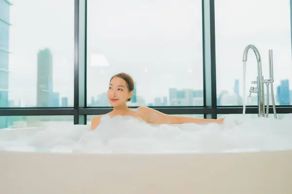 美丽动人的年轻亚洲女人在浴室的浴缸里放松微笑休闲 — 图库照片
