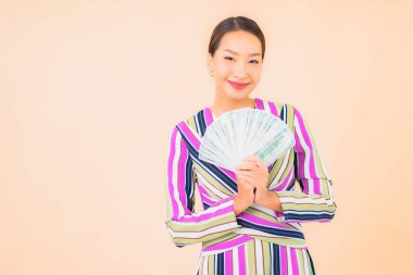 Parası, parası ve cep telefonu olan güzel Asyalı bir kadının portresi.