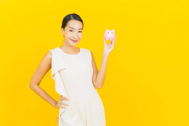 Sarı arka planda domuz kumbaralı güzel Asyalı kadın portresi.