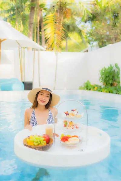 在酒店度假胜地的游泳池上漂浮着下午的茶或早餐 美丽的亚洲年轻女子很享受 — 图库照片