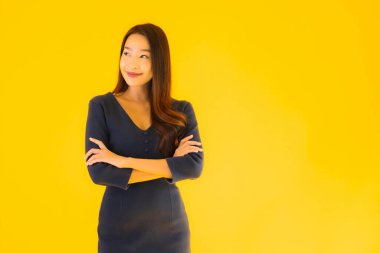 İzole edilmiş sarı arka planda hareketli güzel Asyalı kadın portresi.