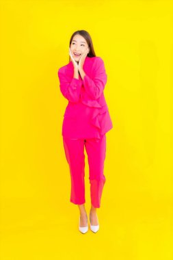 Güzel bir Asyalı kadın sarı arka planda gülümsüyor.