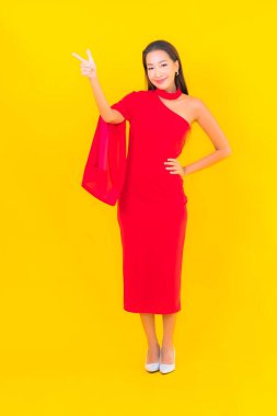 Güzel bir Asyalı kadın portresi. Sarı izole edilmiş arka planda hareketli gülümsüyor.