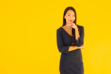 İzole edilmiş sarı arka planda hareketli güzel Asyalı kadın portresi.