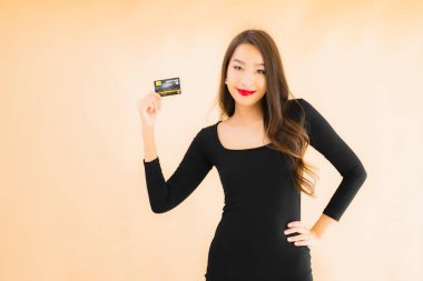 Renkli arka planda alışveriş yapmak için kredi kartı olan güzel bir Asyalı kadın portresi.