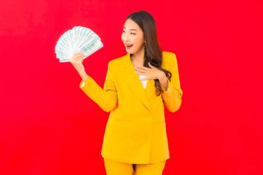 Kızıl arka planda bir sürü parası ve parası olan güzel bir Asyalı kadın portresi.