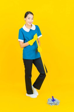 Güzel bir Asyalı kadın portresi ve sarı arka planda hareketli bir gülümseme.