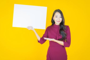 Renkli arka planda boş beyaz ilan panosu olan güzel Asyalı kadın portresi