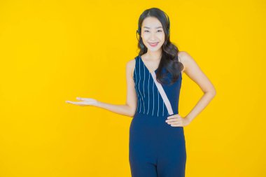 Sarı arka planda çağrı merkezi müşteri hizmetleri merkezi olan güzel Asyalı kadın portresi