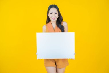Renkli arka planda boş beyaz ilan panosu olan güzel Asyalı kadın portresi