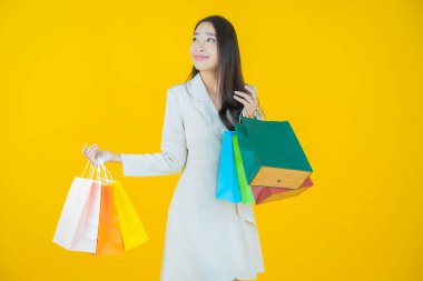 Portre güzel Asyalı kadın tebessümü ile renk arka planında alışveriş torbası