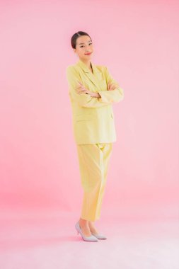 Portre güzel Asyalı genç iş kadını pembe arka planda gülümsüyor