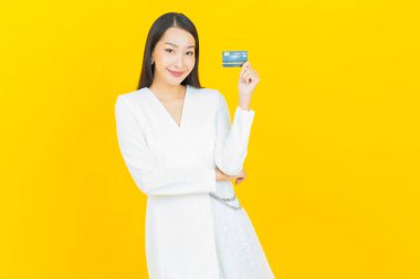 Güzel bir Asyalı kadının portresi. Renkli kredi kartıyla gülüyor.