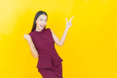 Portre güzel Asyalı kadın gülümsüyor. Renkli arka planda hareket var.