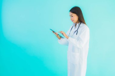 Steteskoplu ve akıllı tabletli güzel Asyalı doktor kadının portresi mavi arka planda hastane ve klinikte kullanılacak.