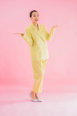 Portre güzel Asyalı genç iş kadını pembe arka planda gülümsüyor