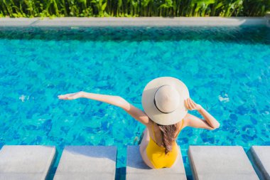 Güzel bir Asyalı kadın portresi. Rahatlayın. Keyifli bir tatil için oteldeki yüzme havuzunda mutlu bir gülümseme.