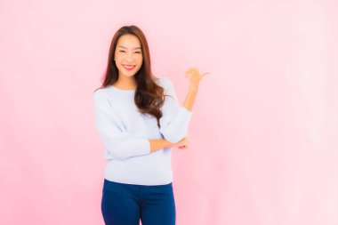 Portrait beautiful young asian woman smile with action on pink isolated background