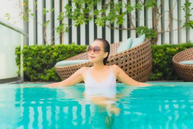 Güzel bir Asyalı kadın portresi. Seyahat tatili için otel havuzunda rahatça yüzebiliyor.