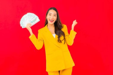 Kızıl arka planda bir sürü parası ve parası olan güzel bir Asyalı kadın portresi.