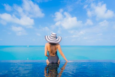 Güzel bir Asyalı kadın portresi. Rahatlayın. Okyanus manzaralı, tatil köyündeki yüzme havuzunda rahatlayın.