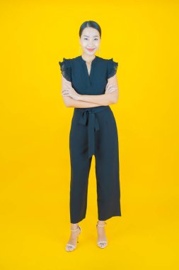 Portre güzel Asyalı kadın gülümsüyor. Renkli arka planda hareket var.