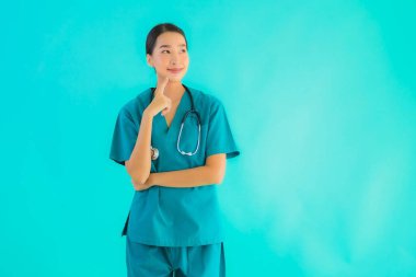 Güzel Asyalı genç doktor kadın gülümsüyor mavi izole arka planda birçok hareketle