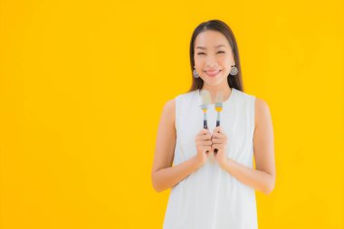 Sarı izole arka planda çatal kaşıklı güzel bir Asyalı kadın portresi.