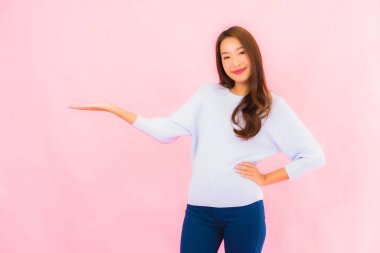 Portrait beautiful young asian woman smile with action on pink isolated background