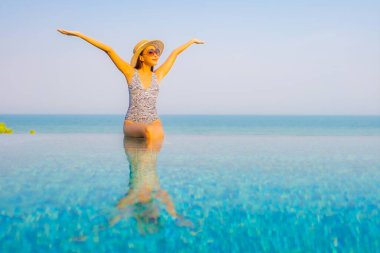Güzel bir Asyalı kadın portresi. Rahatlayın, gülümseyin. Tatil için oteldeki yüzme havuzunun keyfini çıkarın.