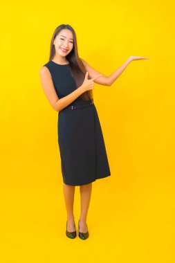 Güzel Asyalı iş kadını portresi. Sarı arka planda hareketli bir gülümseme.