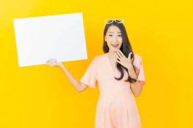 Renkli arka planda boş beyaz ilan panosu olan güzel Asyalı kadın portresi