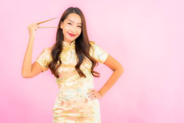 Pembe arka planda çubukları olan güzel bir Asyalı kadın portresi.