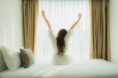 Genç Asyalı mutlu gülümseme. Yatak odasında iç tarafta rahatla.