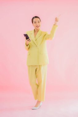 Güzel Asyalı iş kadını portresi. Arka planda kahve fincanı ve akıllı cep telefonu kullanıyor.