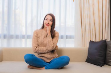 Güzel bir Asyalı kadın portresi rahatla. Gülümse. Yatak odasının iç dekorasyonunda mutlu ol.