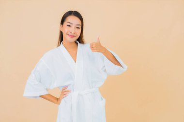 Güzel bir Asyalı kadın portresi. Üzerinde gülücük olan bir bornoz giyiyor.