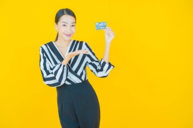 Güzel bir Asyalı kadının portresi. Renkli kredi kartıyla gülüyor.