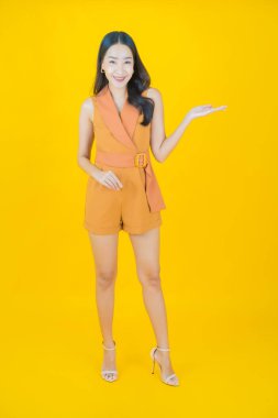 Portre güzel Asyalı kadın gülümsüyor. Renkli arka planda hareket var.