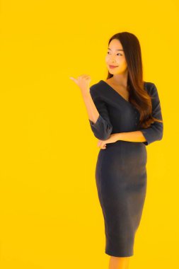 İzole edilmiş sarı arka planda hareketli güzel Asyalı kadın portresi.