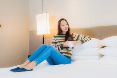 Güzel bir Asyalı kadın portresi. Yatak odasında rahat bir gülümseme.