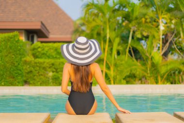 Güzel bir Asyalı kadın portresi. Rahatlayın, gülümseyin. Tatil için oteldeki yüzme havuzunun keyfini çıkarın.